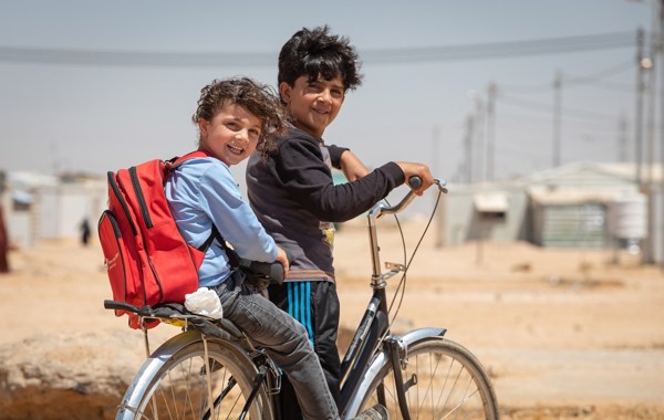 CH1363225 Bilal, 12, Takes His Brother Faisal, 5, To An Early Learning Centre On The Family Bicycle, In Za’Atari Camp For Syrian Refugees, Jordan