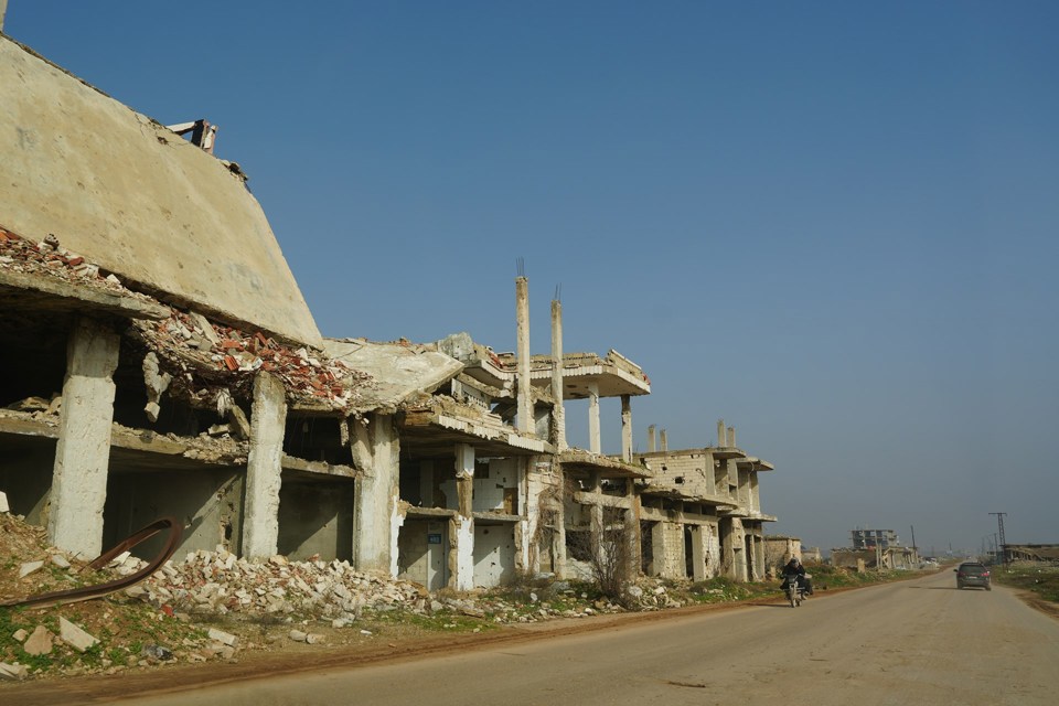 Ruiner av bygninger langs en vei i Syria. 
